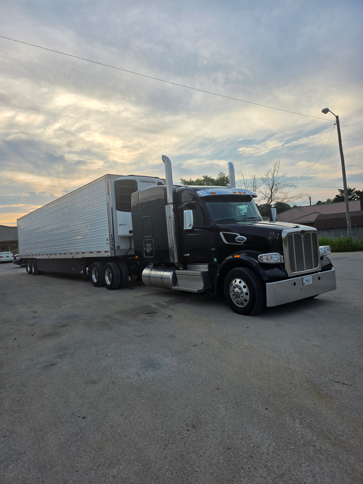 New Haven Express’s black Peterbilt and refrigerated trailer at sunset